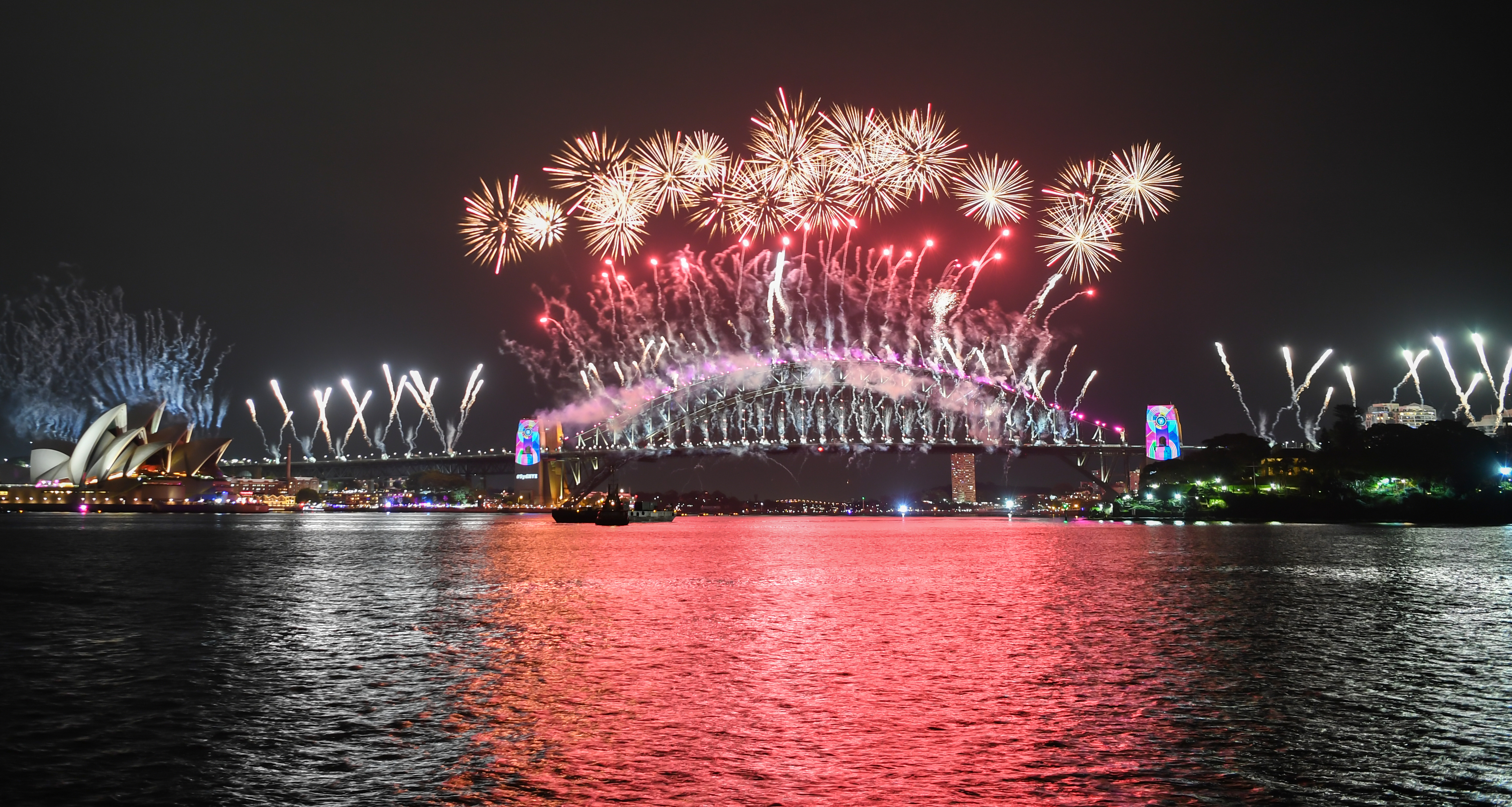 The Sydney Harbour Bridge is bathed in fireworks and lighting effects during New Year