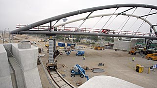 a metal bridge being built at central station, construction equipment and workers in safety vests